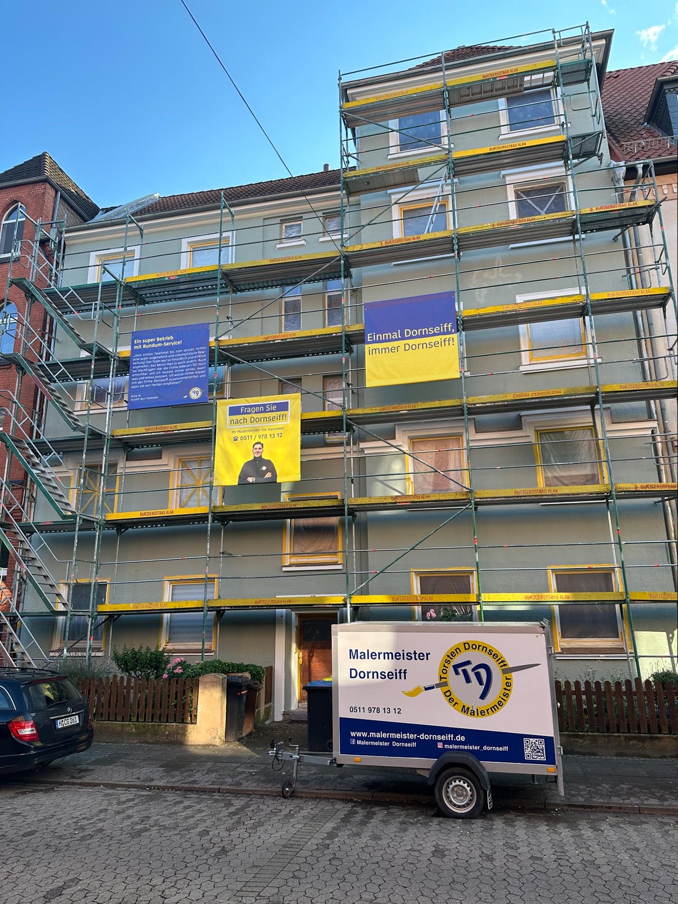 Eingerüstetes Mehrfamilienhaus mit Bannern von Malermeister Dornseiff in Hannover